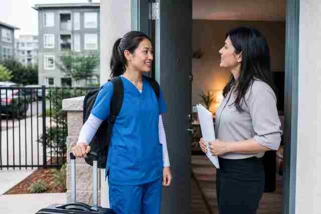 Travel surgical technologist in scrubs with a suitcase in a hospital lobby