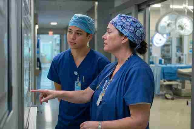 New surgical technologist in scrubs being oriented by a preceptor in an operating room